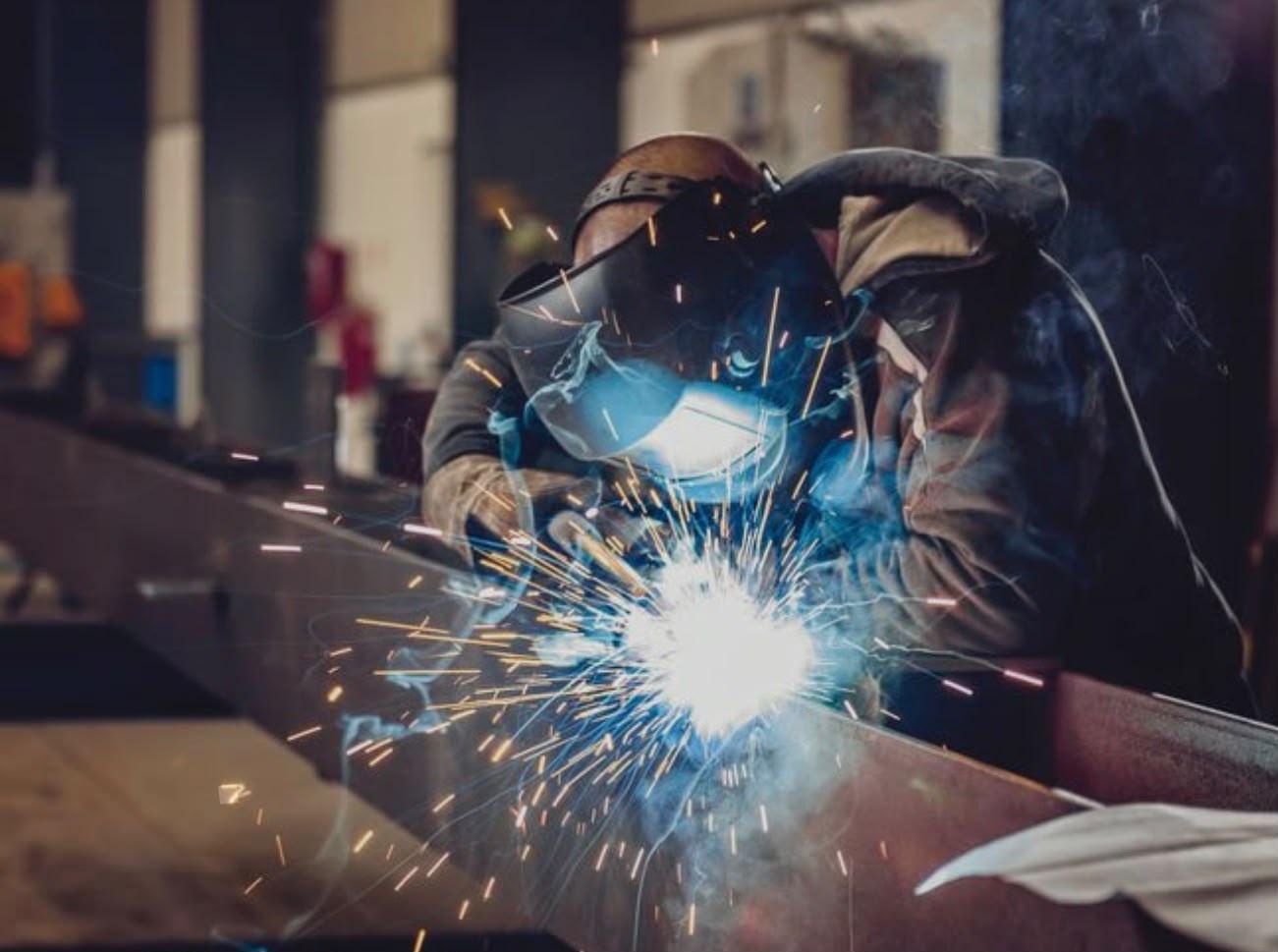 Técnico soldando estructura metálica industrial